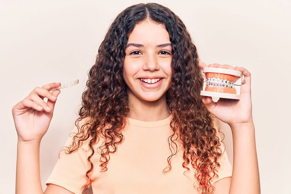 Kind mit Modell und Zahnschiene